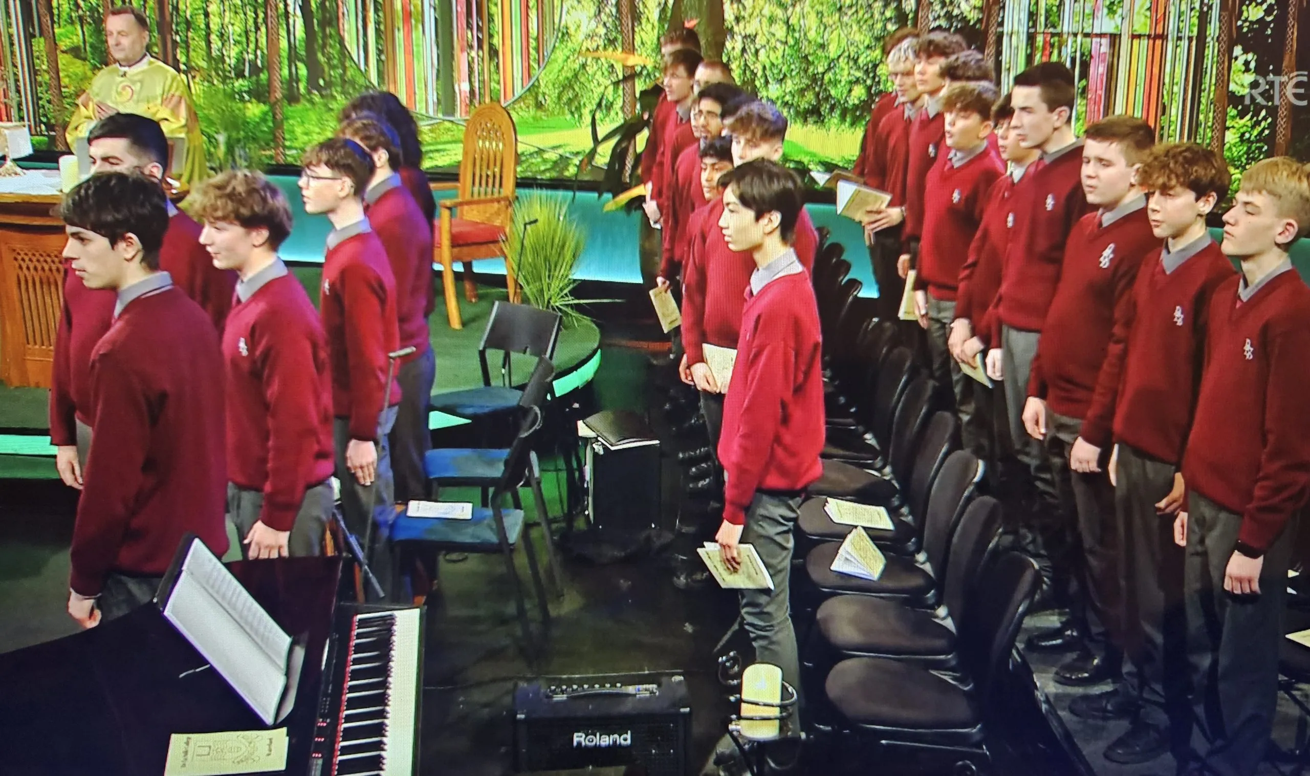 Students in maroon jumpers assembled in the college hall
